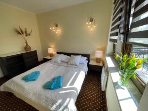 sypialnia z łóżkiem z niebieskimi kapciami w obiekcie Apartament Krynica Morska Continental w mieście Krynica Morska