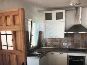 uma cozinha com um lavatório e um fogão forno superior em apartamento em Almería
