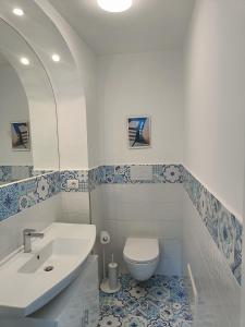 a white bathroom with a toilet and a sink at Regina Margherita in Positano +31 photos