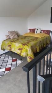 a bed with a yellow blanket on top of a rail at LOCATIONS VERT EDEN in La Plaine des Cafres