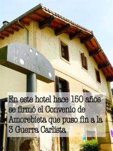 una señal en un poste frente a un edificio en Hotel Konbenio, en Amorebieta-Etxano