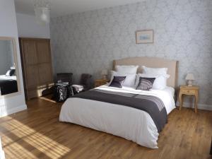 een slaapkamer met een groot bed met witte lakens bij Logis de L'Arceau in Celles