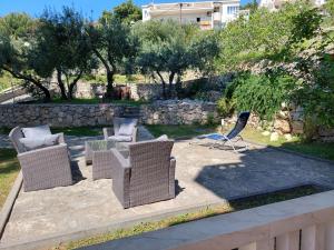 een groep rieten stoelen en tafels op een patio bij Villa Rosso in Baška Voda