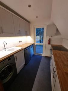 a kitchen with a sink and a washing machine at Seaside Chalet - Sleeps 6 in Kingsdown