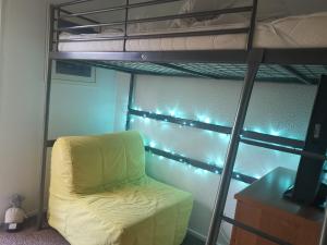a bed and a chair in a room with a bunk bed at Seaside Chalet - Sleeps 6 in Kingsdown