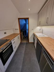 a kitchen with white cabinets and a sink and a counter at Seaside Chalet - Sleeps 6 in Kingsdown