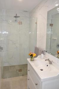 a bathroom with a sink and a glass shower at The stables in Wandin North