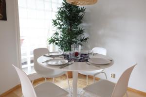 a white dining room table with white chairs and a plant at 2ndhomes Premium 1BR apartment with Sauna and Balcony in Kamppi Center in Helsinki