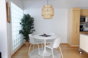 a white dining room with a white table and chairs at 2ndhomes Premium 1BR apartment with Sauna and Balcony in Kamppi Center in Helsinki