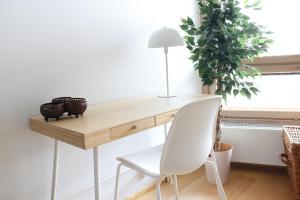 a desk with a white chair and a lamp at 2ndhomes Premium 1BR apartment with Sauna and Balcony in Kamppi Center in Helsinki