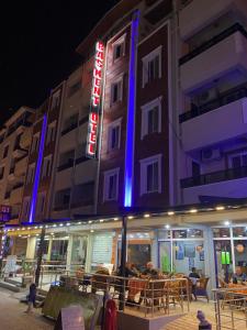 a hotel with people sitting outside of it at night at Baskent Otel in Didim