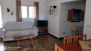 a living room with a couch and a tv at Casa Beja in Sant Francesc Xavier