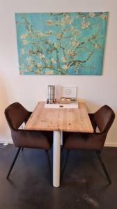 une table en bois avec une chaise et une photo sur le mur dans l'établissement Oude Meesters, à Bolsward