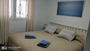 a bed with two blue towels on top of it at Casa Beja in Sant Francesc Xavier