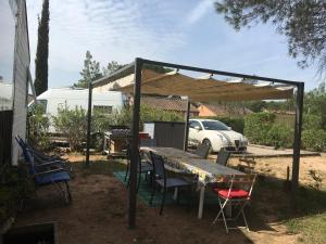a table and chairs under a tent in a yard at Oasis village in Puget-sur-Argens
