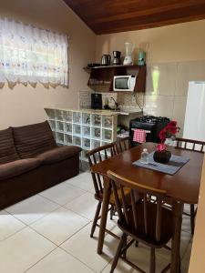 a kitchen and living room with a table and a couch at Apartamento em João Fernandes - Búzios in Búzios