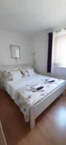 a bedroom with a white bed with a floral blanket at Peace and quiet apartment in Brela, Croatia in Brela