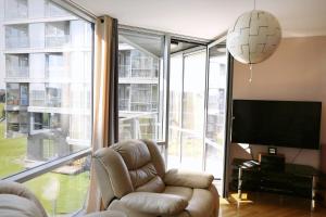 a living room with a couch and a chair and a large window at Elija in Šventoji