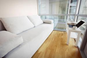 a white couch in a room with a table with a laptop at Elija in Šventoji