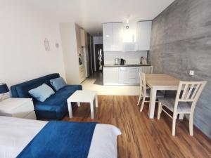 - un salon avec un canapé bleu et une table dans l'établissement Sea&Forest Pogorzelica Apartament Perłowy, à Pogorzelica