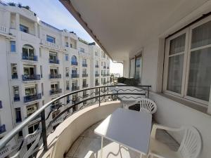 a balcony with a table and chairs and a building at Palais des Iles in Cannes