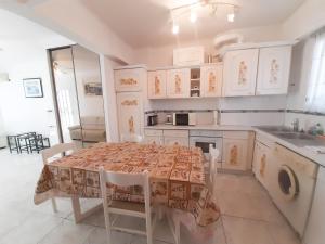 una cocina con mesa con sillas y una cocina con armarios blancos. en Palais des Iles, en Cannes
