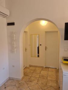 einen Torbogen in einem Zimmer mit einer Tür und Fliesenboden in der Unterkunft Vila Virago in Vir