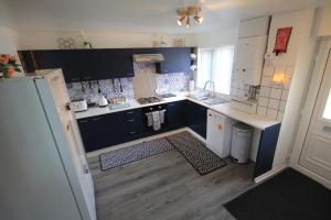 a small kitchen with blue cabinets and a sink at Home From Home in Stanhope