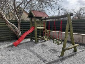 a playground with a red slide and a tree at Pensiunea Bella Praid in Praid