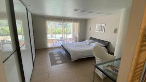 a small bedroom with a bed and a glass table at Villa San Marco chambre d hôtes in Lorgues