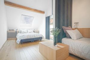 Maison Eliacé في Heure: غرفة معيشة مع سرير وأريكة