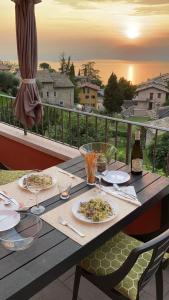 a wooden table with plates of food and wine glasses at Casa Giuditta in Torri del Benaco