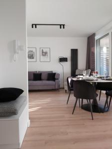 ein Wohnzimmer mit einem Tisch und einem Sofa in der Unterkunft Apartament 150 Zaspa VVita z ogrodem i tarasem in Danzig