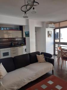 a living room with a couch and a kitchen at Apartamento en la playa in Torremolinos