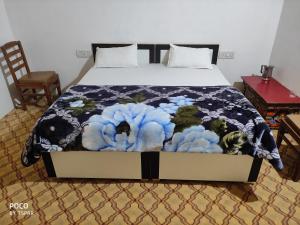 a bed with a blue and white comforter on it at Buddha guest House nubra in Deskit