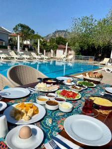 a table with plates of food next to a pool at Safak Hotel Dalyan in Dalyan