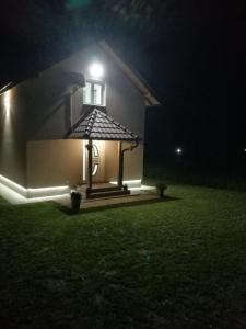 uma casa com uma luz de lado à noite em Biser na Drini em Velika Reka