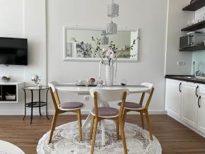 a white dining room with a table and chairs at Vacanza, Sea view in Kotor