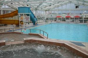 een groot binnenzwembad met een glijbaan bij The Pearl - Deluxe Access Caravan in Skegness