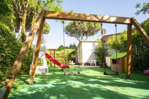 a playground with a slide in a yard at Camping Linus in Marina di Massa