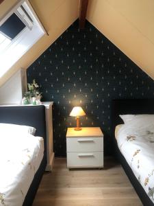sypialnia z 2 łóżkami i lampką na stoliku nocnym w obiekcie De Spaier 3a w mieście Zoutelande