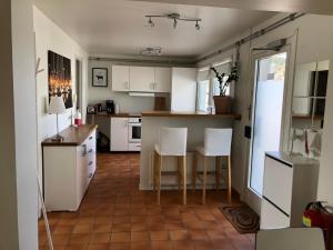 cocina con armarios blancos, mesa y sillas en Apartments in Henån en Henån