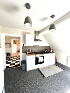 cocina con armarios blancos y fogones en Duisburg FeelHome, Flughafen nah,2-Schlafzimmer, Badewanne, Zentral, WiFi, Top Floor, en Duisburg