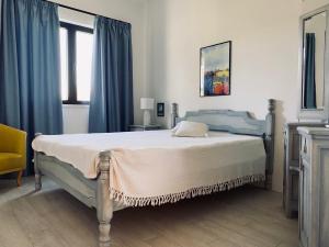 Schlafzimmer mit einem großen Bett und blauen Vorhängen in der Unterkunft Zora’s Home in Irig