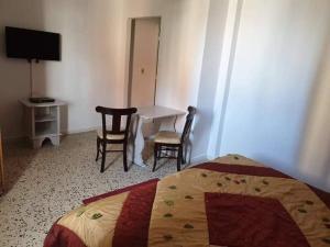 Schlafzimmer mit einem Bett, einem Tisch und Stühlen in der Unterkunft Rimel El corniche in Sousse