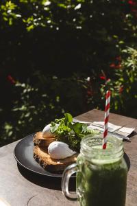 a sandwich on a plate with a drink on a table at Holly Day's - 1910 cottage - right by the beach in Glenelg