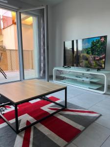 uma sala de estar com uma televisão e uma mesa de centro em Résidence neuve le K 10 mn gare, parking , tram em Montpellier