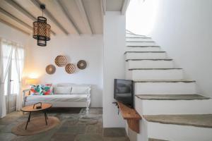 salon ze schodami i kanapą w obiekcie Enea by TinosHost w mieście Tinos