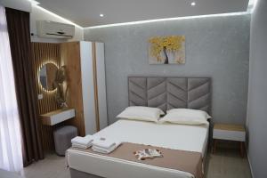 a small bedroom with a bed and a mirror at Apartments Costa Azzurra in Velipojë +217 photos
