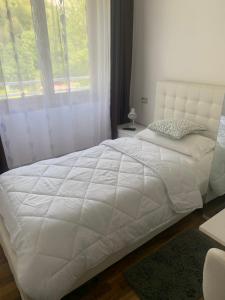 1 cama blanca en un dormitorio con ventana en Albergo al lago, en Anfo